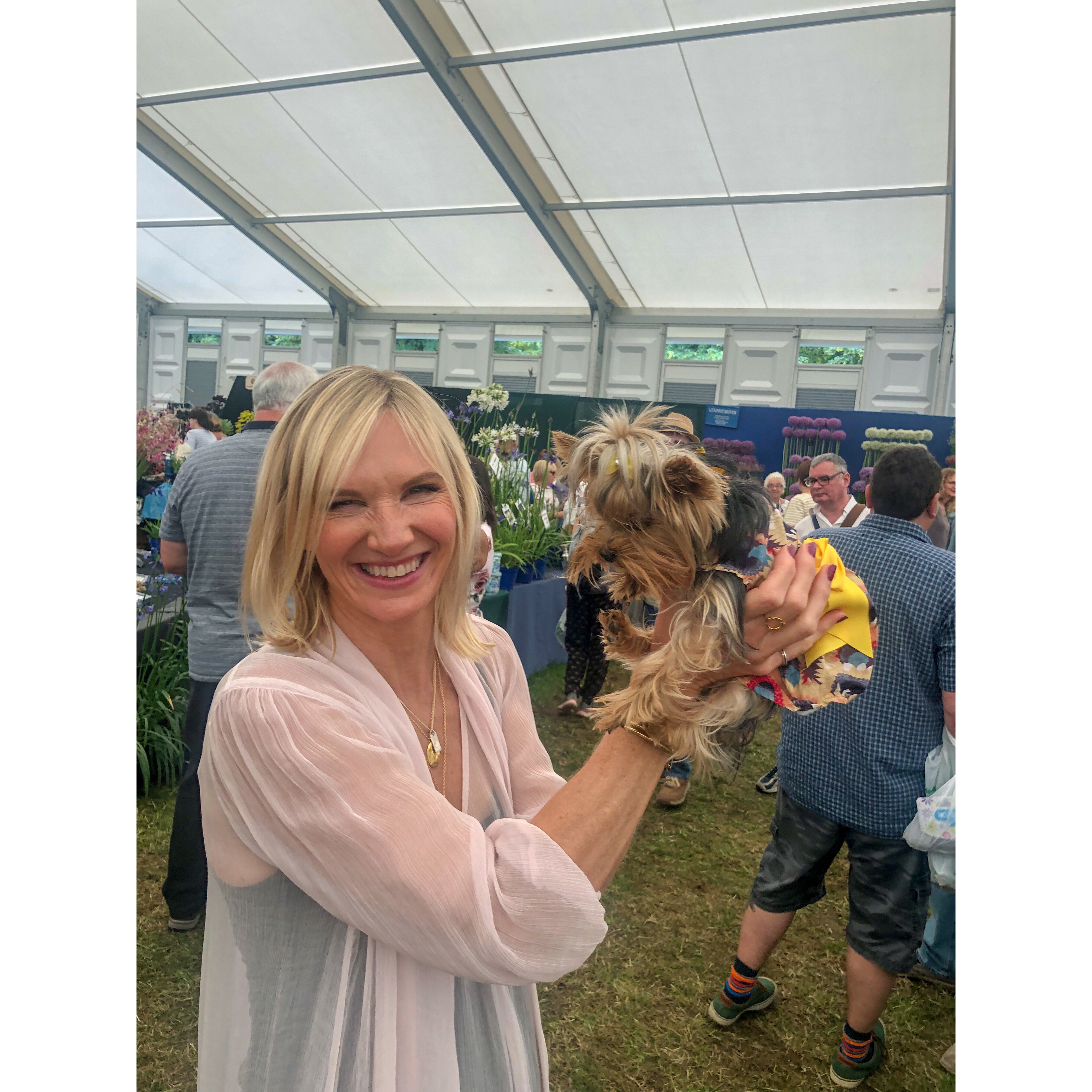 Esme being held up by Jo Whiley at a flower show