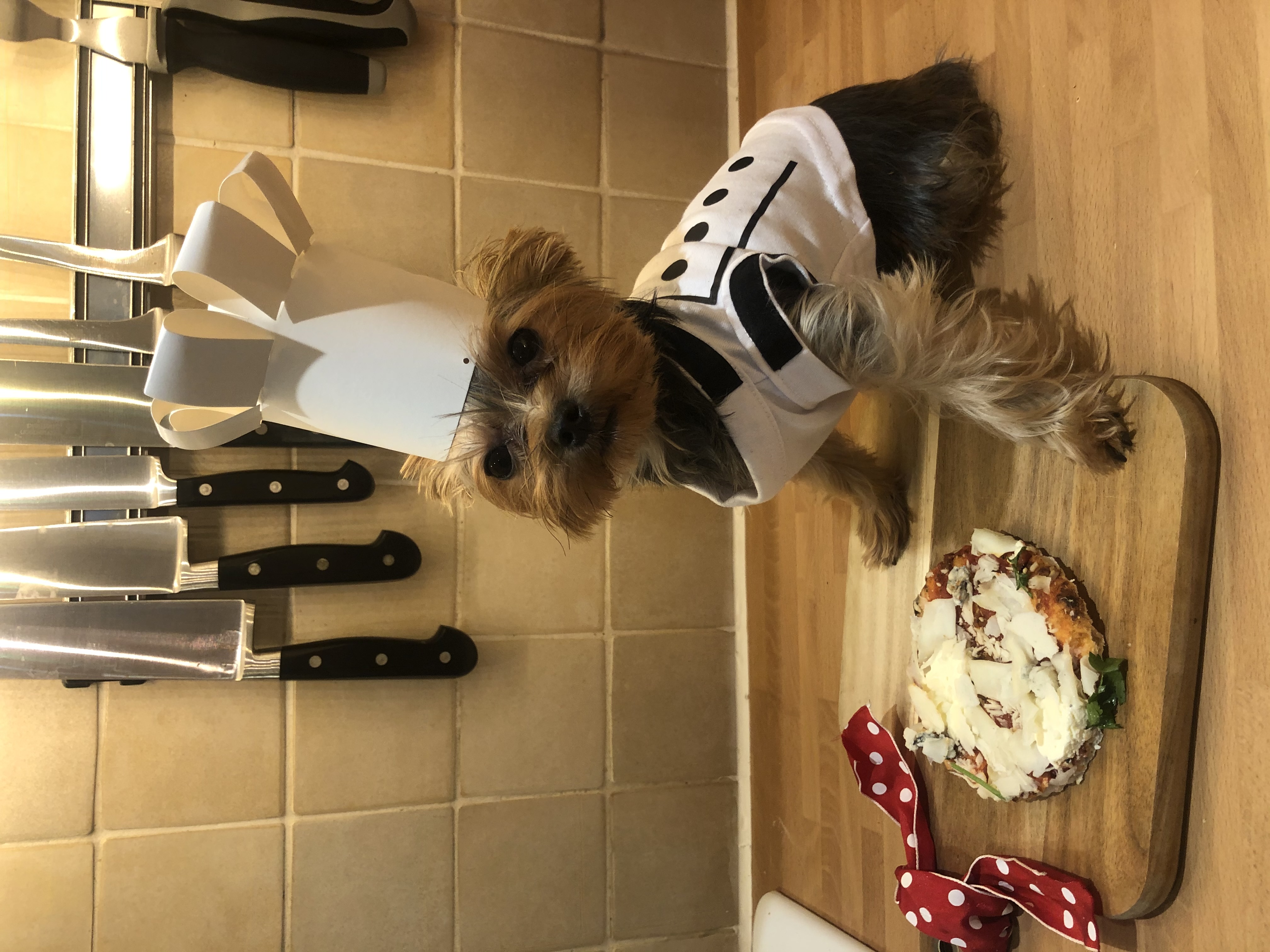 Esme dressed as a chef with a homemade pizza